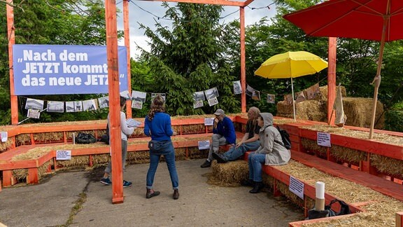 Mit Stroh gepolsterte Bänke laden auf dem Festival Osten ein, sich zu setzen und miteinander zu diskutieren.