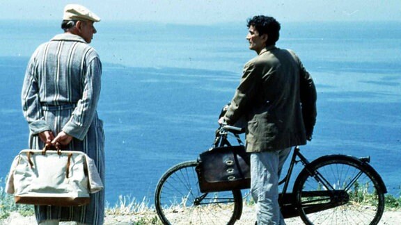 Szene aus dem Film "Der Postmann": Zwei Männer stehen am Strand, einer von ihnen ist der Dichter Pablo Neruda