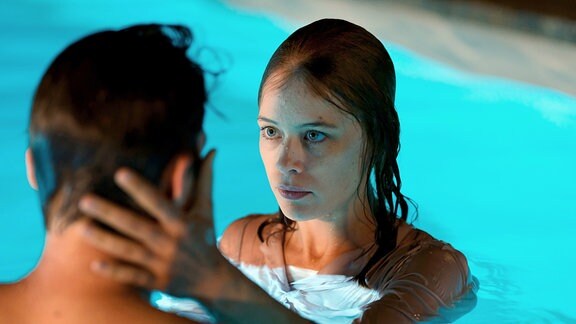 Szene aus dem Film ''Undine''. Eine Frau und ein Mann im Swimmingpool.