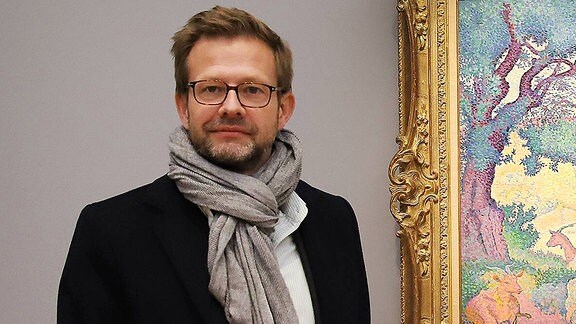 Der Autor Florian Illies steht vor einem Gemälde