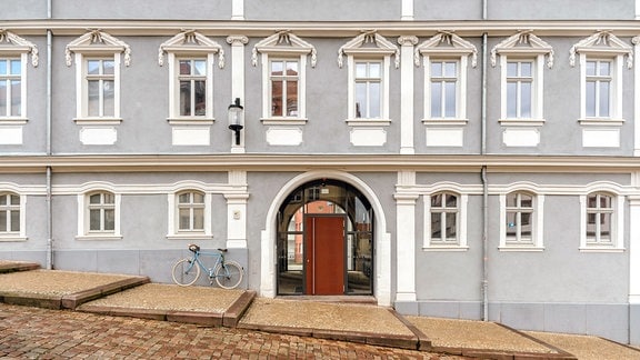 Gebäude des Forschungszentrums in Gotha, ein mehrstöckiges Gebäude mit gräulicher Fassade und weiß verzierten Fenstern.  