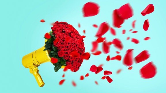 Kreativer gelber Lautsprecher mit einem Strauß roter Rosen und fliegenden Blütenblättern auf pastellgrünem Hintergrund
