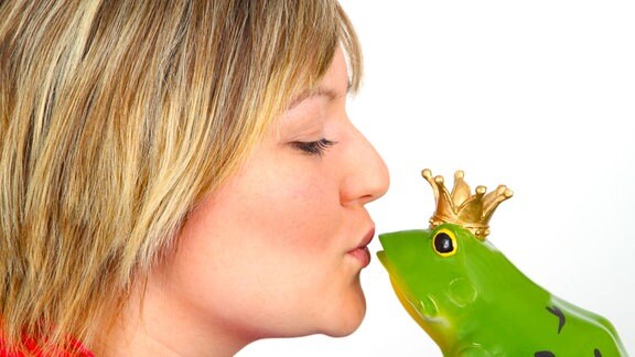 Frau mit Kussmund vor Froschfigur mit Krone