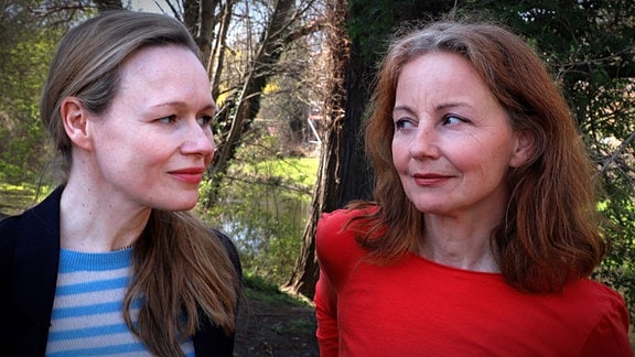 Die Schauspielerinnen Carina Wiese in rotem Pberteil und Anja Schneider in blau-weiß gestreiften Oberteil