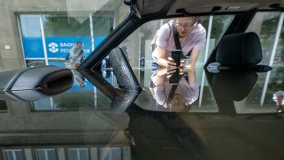 Wasser steht in einem BMW, eine Person macht davon ein Foto mit dem Handy