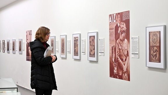 Eine Frau in der Ausstellung "33 Geistesblitze. Antifaschistische Fotomontagen von John Heartfield, 2024 neu gelesen"