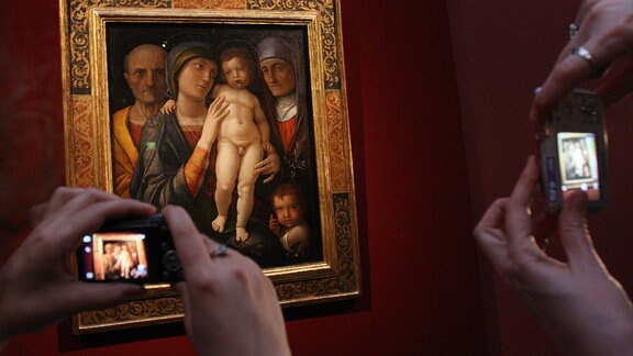 Besucher fotografieren das Gemälde "Die heilige Familie"