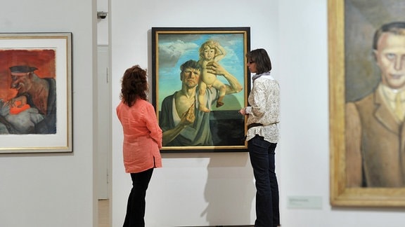 Zwei Frauen betrachten das Gemälde "Selbstbildnis mit Jan" von Otto Dix