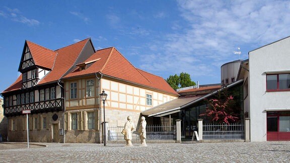 Blick auf das Gleimhaus in Halberstadt: links ein historisches Haus mit Fachwerk-Elementen und heller Fassade, links eine Neubau mit stark angeschrägtem Dach.