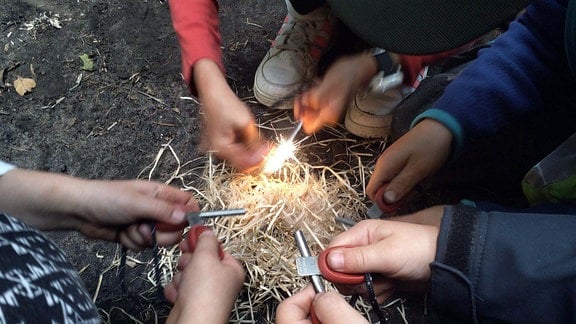 Kinder lernen wie man in der Steinzeit Feuer macht