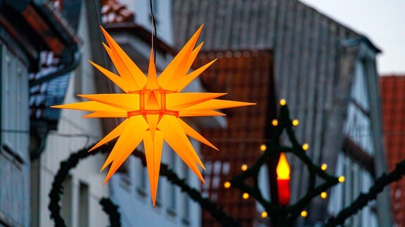 Ein gelber Herrnhuter Stern als weihnachtliche Straßenbeleuchtung