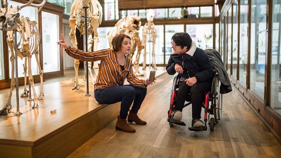Eine Sozialarbeiterin begleitet eine behinderte Frau bei einem Besuch des Naturkundemuseums Nantes, Frankreich 