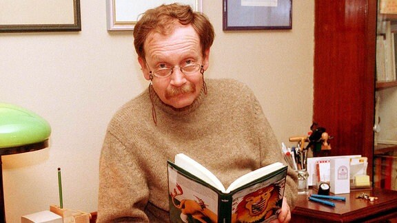 Kabarettist Jürgen Hart liest ein Buch in seinem Büro in seiner Wohnung in Berlin. 2000