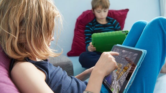 Kinder spielen auf ihren Ipads das Open-World-Computerspiel Minecraft.