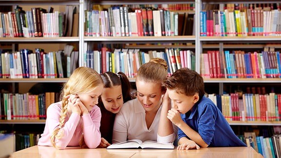 Kinder lesen in einem Buch.