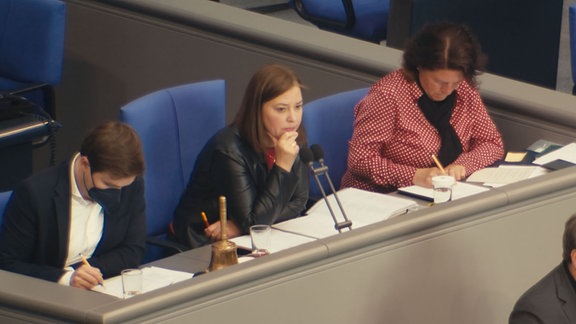 Drei Politikerinnen sitzen im Bundestag, eine trägt eine FFP2-Maske.