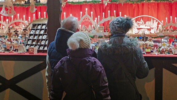 Menschen vor einem Stand auf einem Weihnachtsmarkt