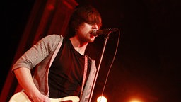 Klez.e-Sänger Tobias Siebert, ein Mann mit braunen Haaren steht mit einer Gitarre vor eibem Mikro und singt | Bildrechte: imago images/POP-EYE Klez.e-Sänger Tobias Siebert, ein Mann mit braunen Haaren steht mit einer Gitarre vor eibem Mikro und singt