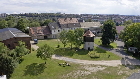 Drohnenaufnahme vom Gelände Posa, zu sehen sind Teile eines ehemaligen Klosters und ein großer, grüner Hof