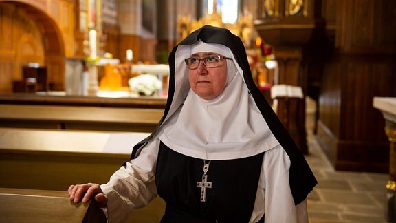 Äbtissin Schwester M. Elisabeth Vaterodt, eine Nonne in Ordnesgewand, sie sitzt in einer Kirche 