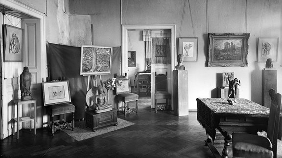 Schwarz-Weiß-Foto: Blick in einen Ausstellungsraum der Kunstausstellung Kühl mit Gemälden, Skulpturen und Möbel.