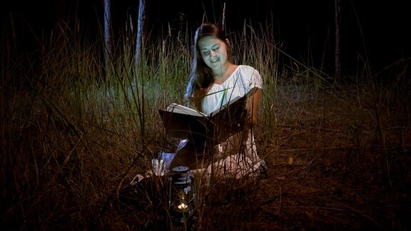 Eine Frau liest in einem Buch.