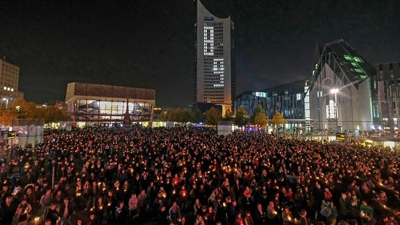 Menschen haben auf dem Augustusplatz in Leipzig mit tausenden Kerzen eine grosse 89 erstellt