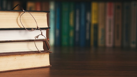 Bücherstapel und Brille