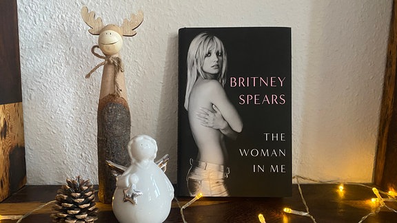 Das Buch "The Woman in Me" von Britney Spears neben Weihnachtsdeko.
