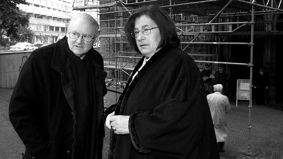 Christa und Gerhard Wolf, beide tragen einen dunklen Mantel, vor einer Kirche