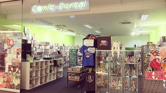Blick in den Eingangsbereich eines Ladens, in dem verschiedene Regale und Vitrinen mit Comics, Mangas und thematisch passende Accessoires stehen 