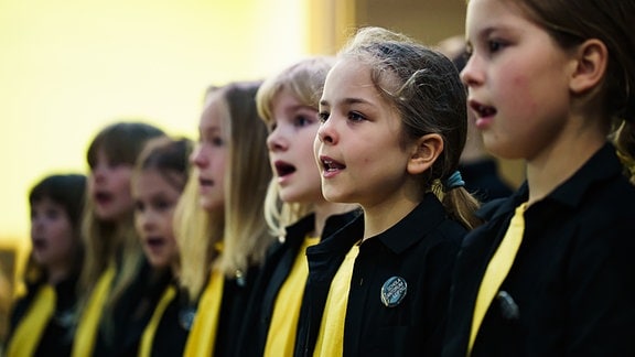 Eine Chorgruppe aus jungen Mädchen singt.