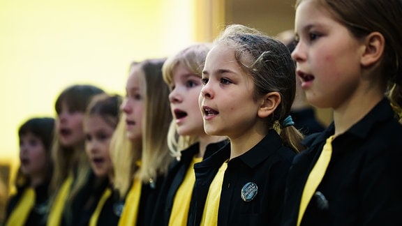 Eine Chorgruppe aus jungen Mädchen singt.