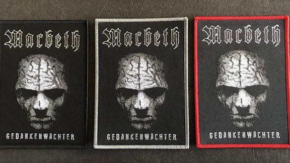 Drei Patches mit der Aufschrift "Macbeth" und "Gedankenwächter" und einem Totenkopf