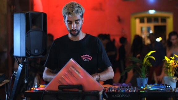 Ein DJ beim Plattenraussuchen auf einer Party