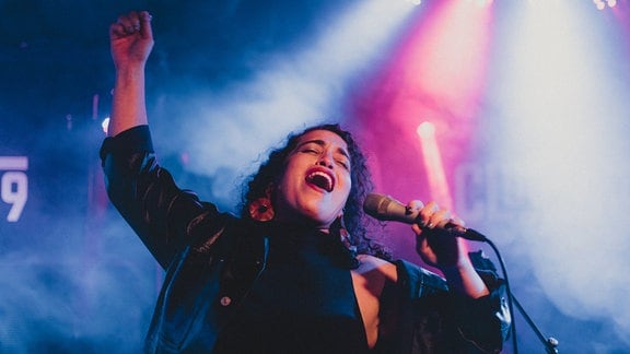 Die Musikerin Naama Guggenheim singt bei einem Auftritt ins Mikrofon.