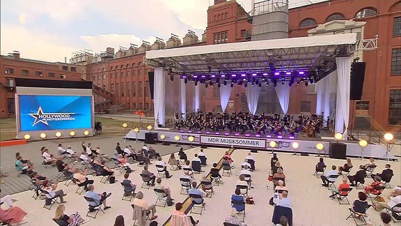 Orchester mit Publikum vor altem Gebäude
