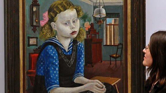 Eine Frau betrachtet das Gemälde 'Mädchen am Sonntag' von Otto Dix.