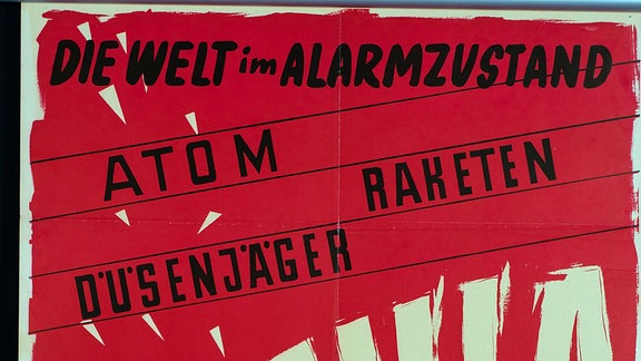  Ein rotes Plakat mit der Aufschrift: Die Welt im Alarmzustand.