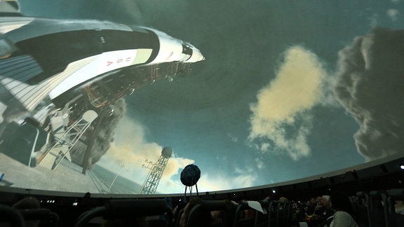 Ein Planetarium zeigt in einer Vürführung die Reise einer Rakete ins Weltall.