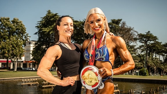 Lena Ramsteiner (rechts) & Trainerin Jennifer Rohde mit der Medaille für die erfolgreiche Qualifikation für Mrs. Olympia in Las Vegas. 