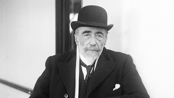 Der Schriftsteller Joseph Conrad steht an der Reling eines Schiffes