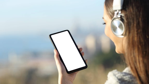 Eine junge Frau mit Kopfhörern und einen Smartphone