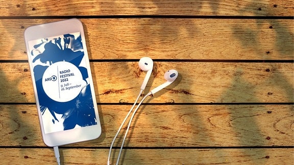 Allgemeines Motiv zum Radiofestival 2022, Ein Smartphone liegt auf einem Tisch, im Display Informationen zum Radiofestival