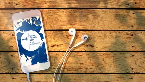 Auf einem Holztisch ein Smartphone mit Ohrhörern: ARD Radiofestival 2023