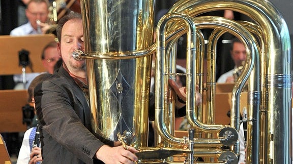 Ein Mann spielt auf der größten bespielbaren Tuba der Welt