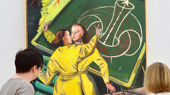 Ausstellungsbesucher betrachten das Gemälde "Gravitation" von Rosa Loy