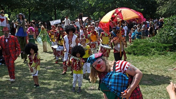 Kinderfest-Szene in einem Rudolstädter Park mit verkleideten Menschen.
