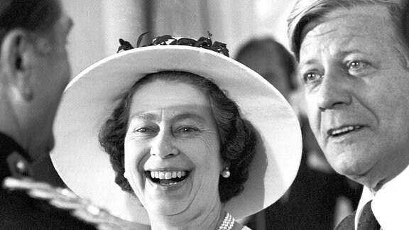 In bester Laune unterhält sich Königin Elizabeth II. auf dem Empfang des Senats im Schloss Charlottenburg in Berlin am 24.05.1978 mit Bundeskanzler Helmut Schmidt (r) und mit dem britischen Stadtkommandanten Robert F. Richardson (l).