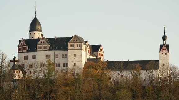Schloss Rochsburg, auf einem Berg gelegen, davor Bäume